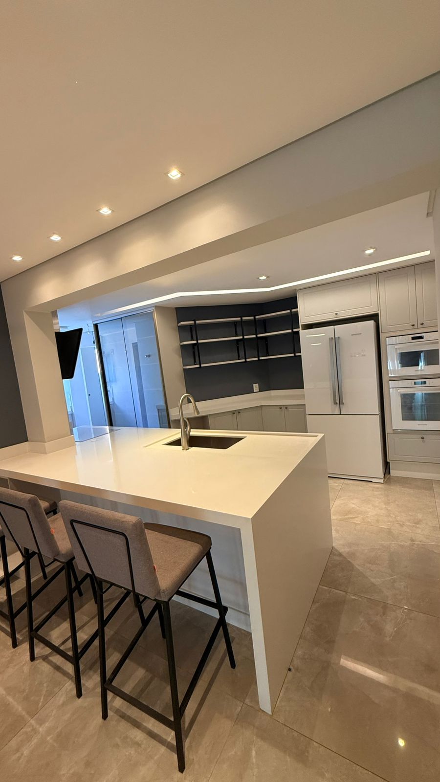 Cozinha planejada com ilha e banquetas